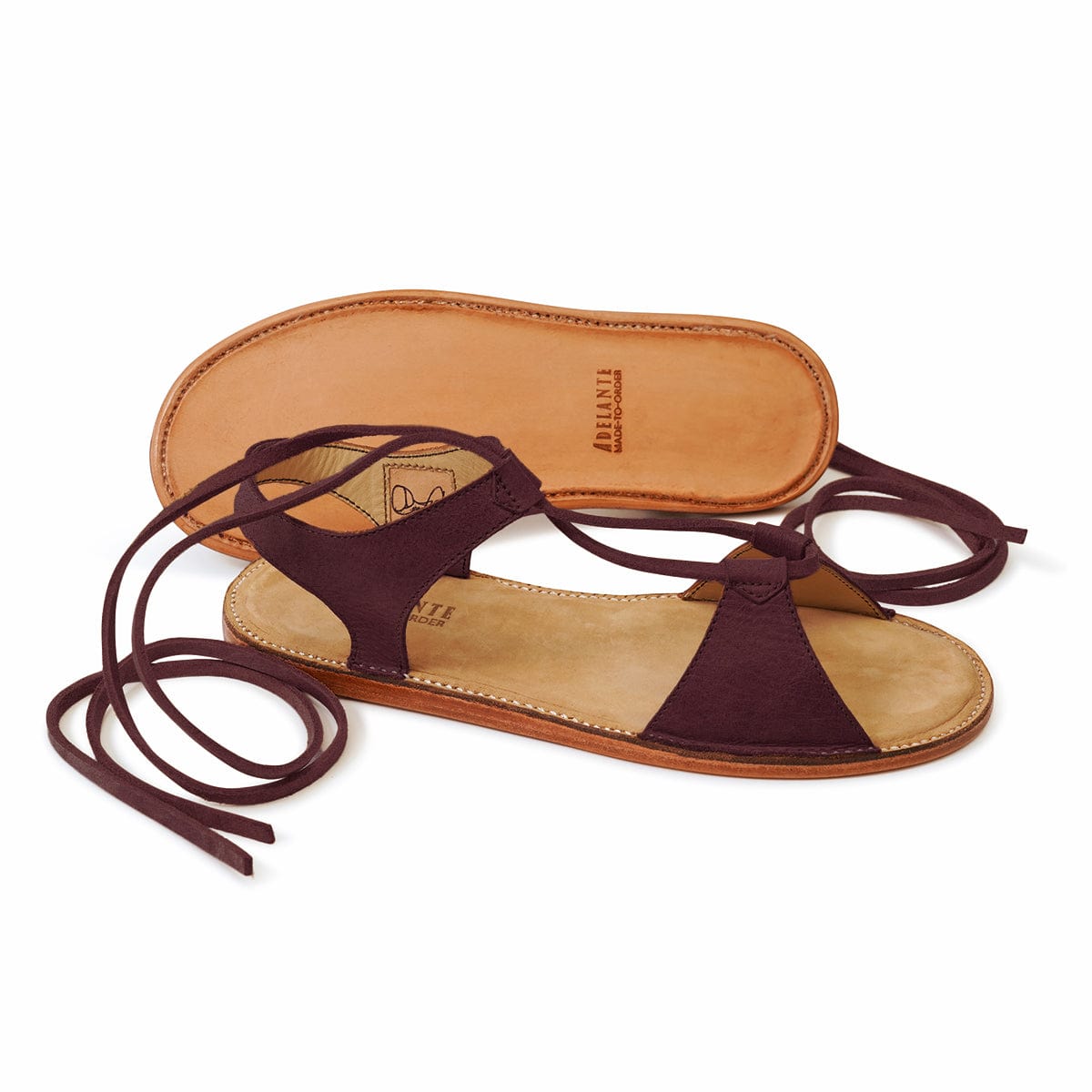 Burgundy women's gladiator sandal with wraparound ankle laces and tan footbed, handcrafted by Adelante artisans