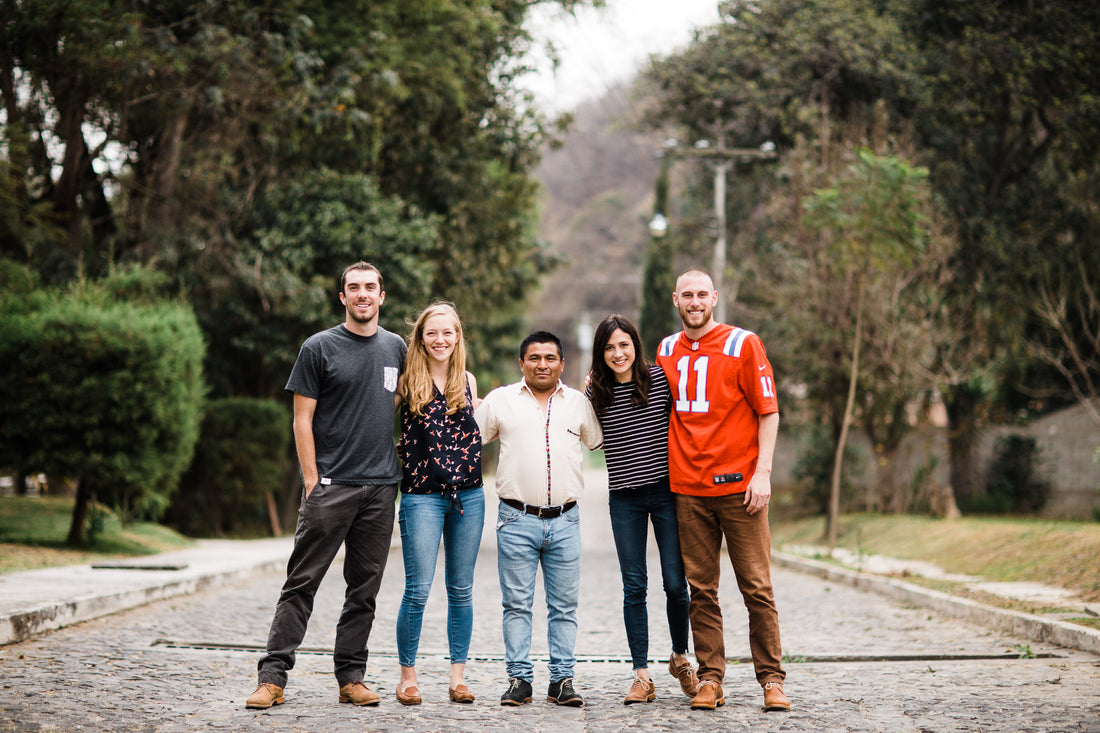 Adelante team of five standing together on a tree-lined street in Guatemala