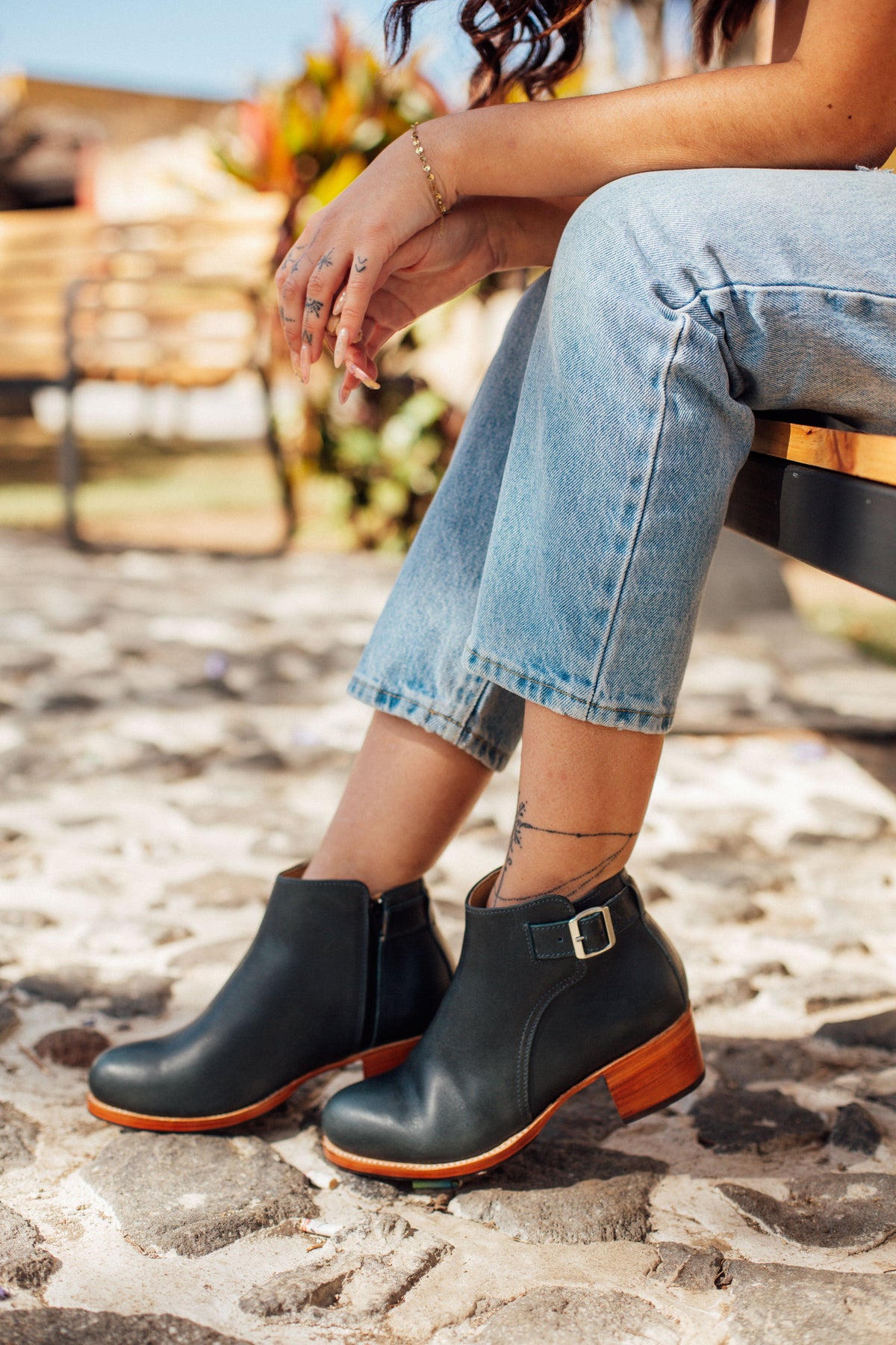 Adelante women's black buckle booties with block heels and orange soles, styled with cropped jeans