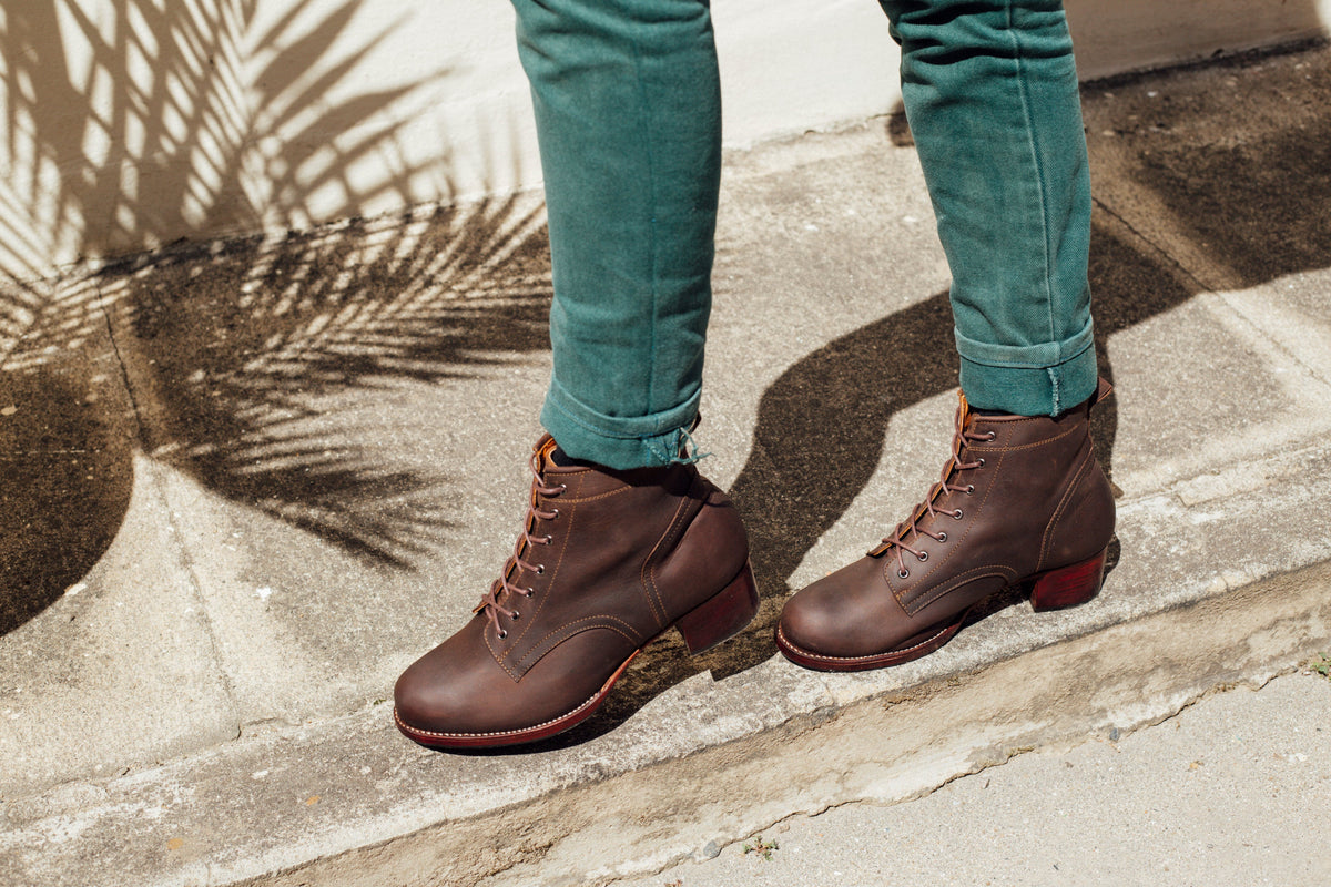 Brown leather womens lace-up combat boots with block heels, worn with teal cuffed jeans by Adelante Made-To-Order
