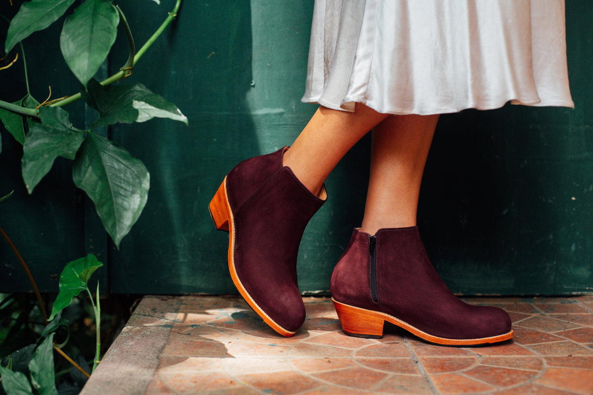 Burgundy leather womens ankle boots with tapered heels styled with a white dress