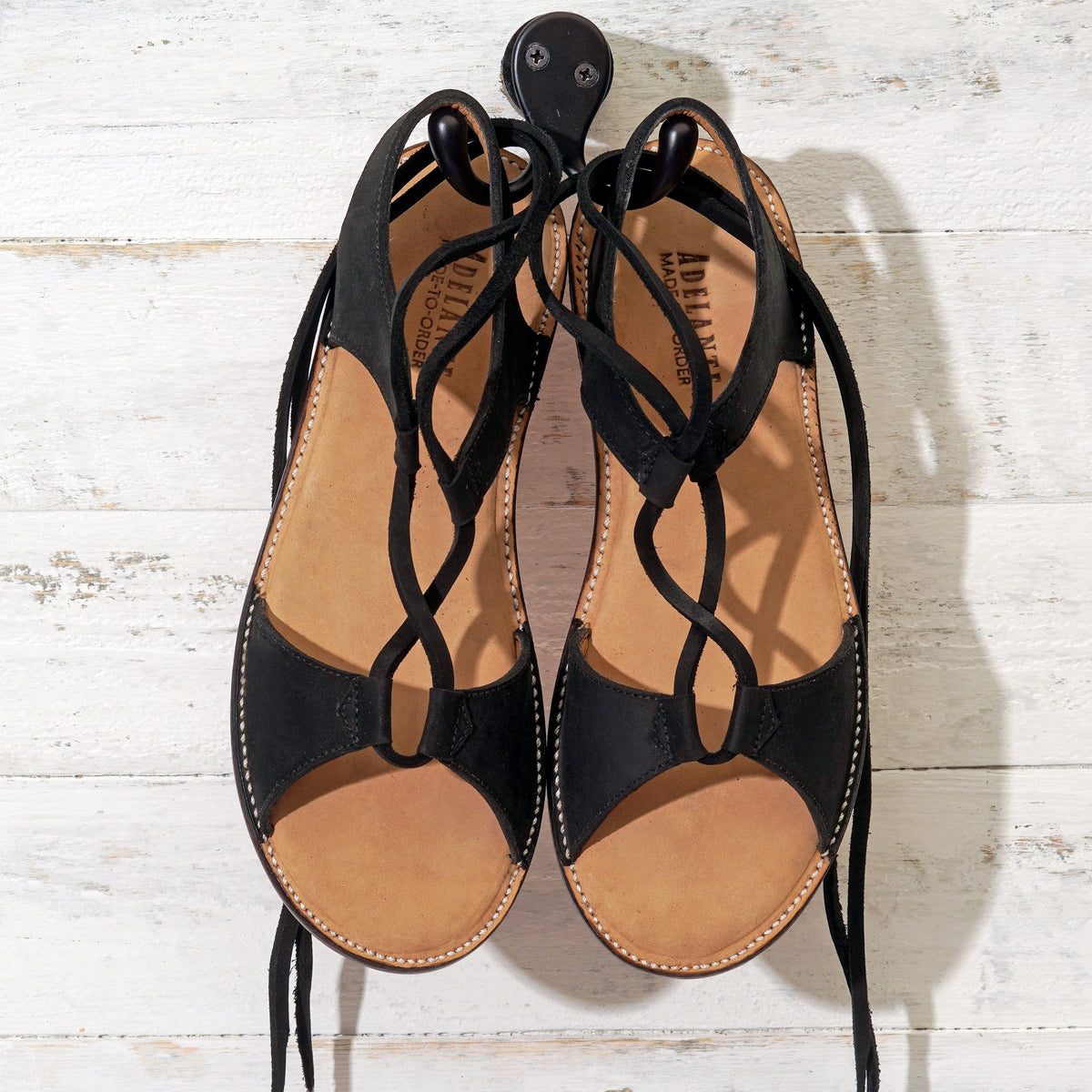 Black women's gladiator sandals with wraparound laces and handcrafted artisan construction by Adelante