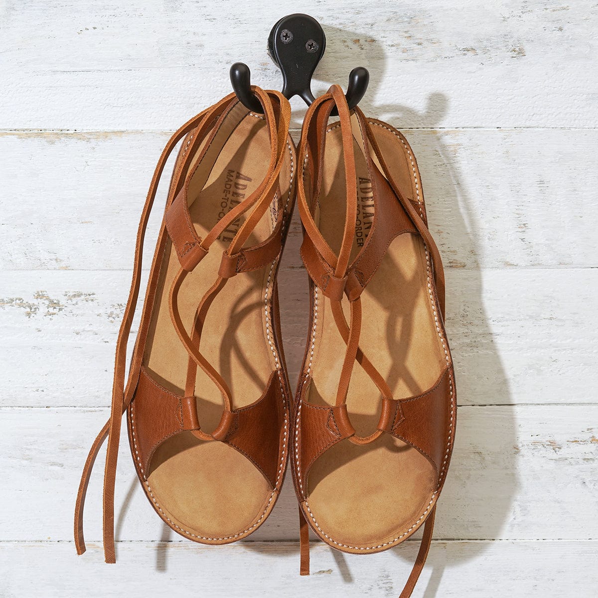 Brown women's gladiator sandals with wraparound laces and open toes, handcrafted by Adelante Made-To-Order