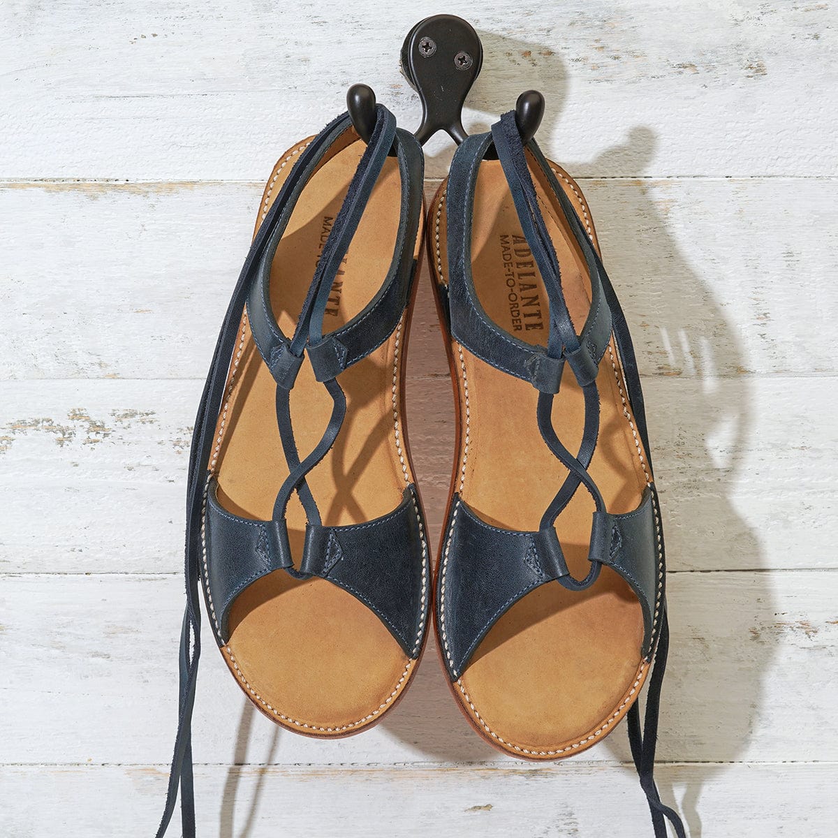 Adelante women's navy gladiator sandals with wraparound laces, handcrafted in Guatemala and available in sizes 4 to 8.5 with wide width options