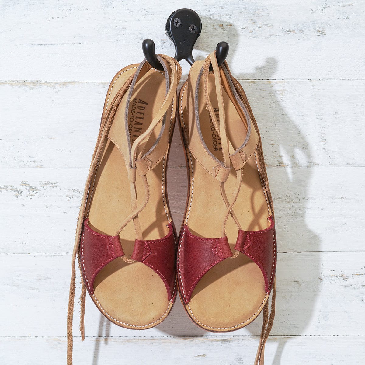 Tan and burgundy women's gladiator sandals with wraparound laces and handcrafted detailing