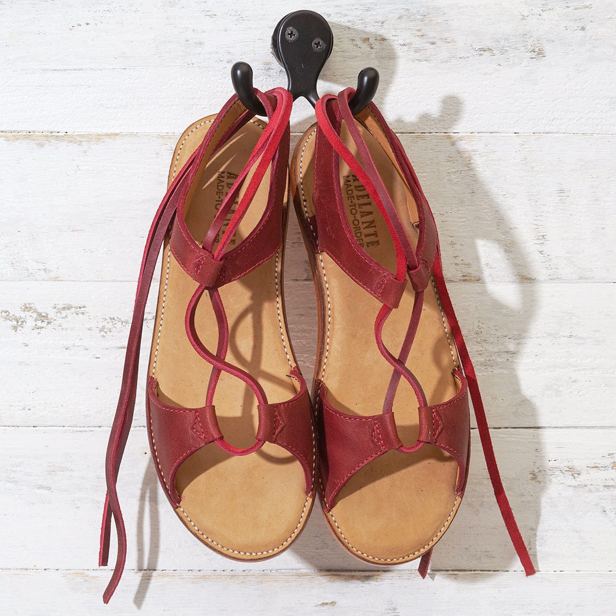Women's red gladiator sandals with wraparound laces and tan footbeds, handcrafted by Adelante artisans