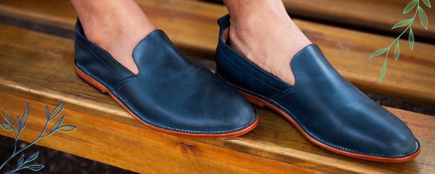 Handcrafted men's leather loafers on a wooden bench from the Adelante Made-to-Order Men's Collection.