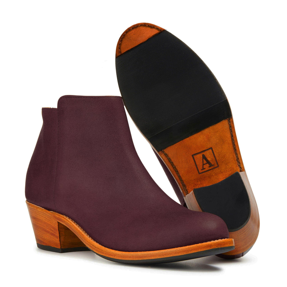 Burgundy leather women’s ankle boot with a sleek pointed toe, tapered stacked heel, and contrasting orange welt detail.