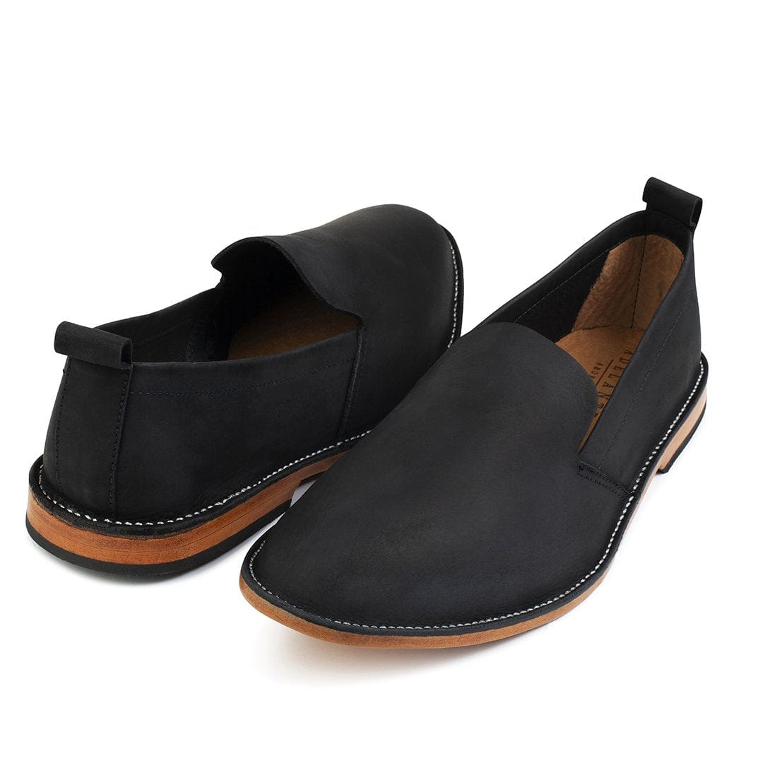 Men's 2E-wide black leather slip-ons, shown at an angle – The Viento