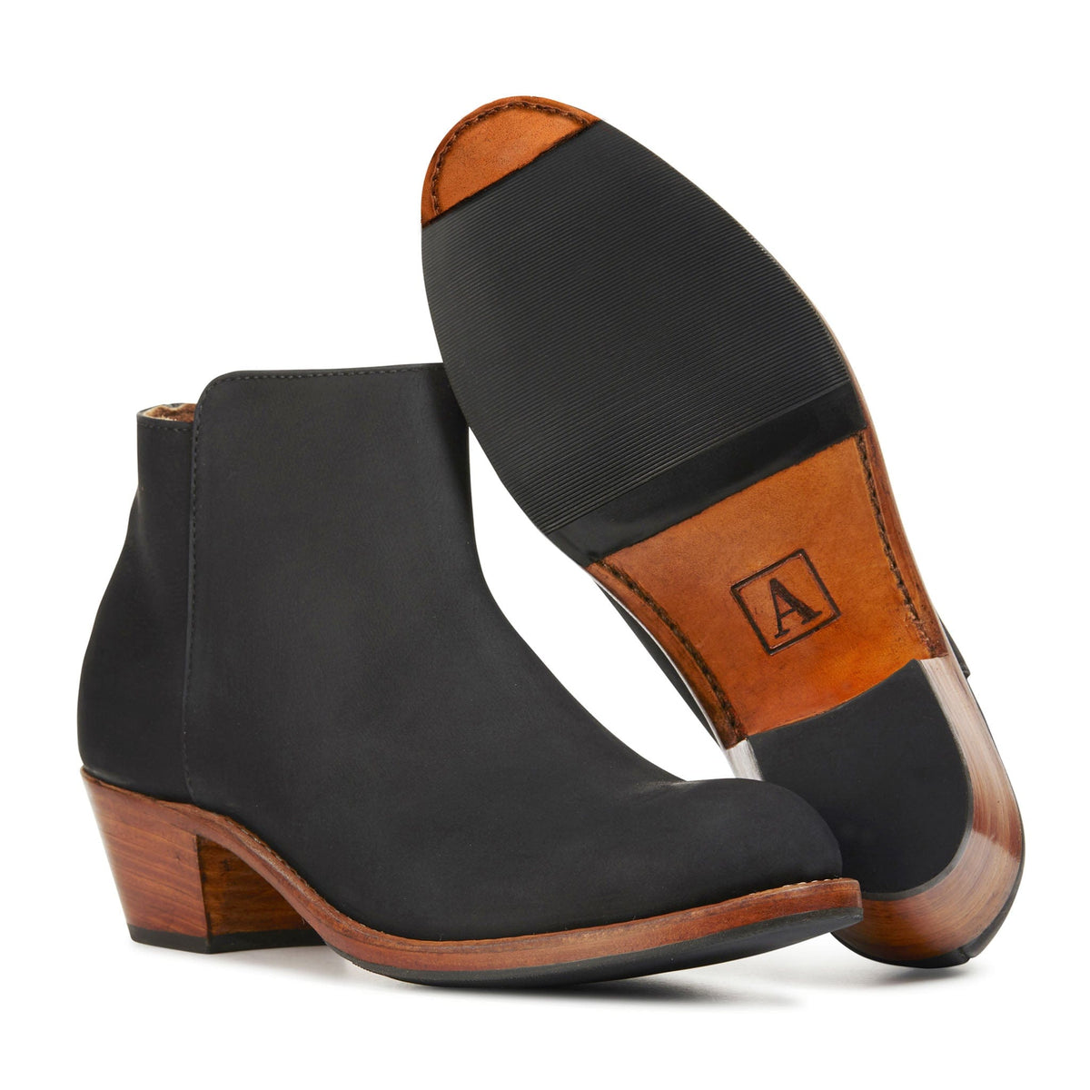 Black womens leather ankle booties with tapered stacked heels and contrasting sole details, shown as a pair by Adelante, available in narrow to extra wide widths