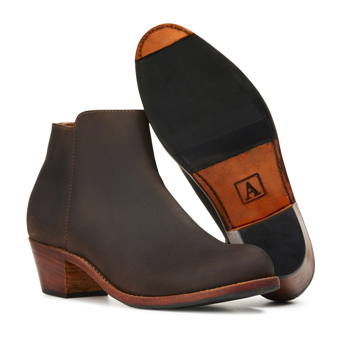 Brown leather women's ankle boot with tapered wood-look heel and branded leather sole, shown with the sole facing forward
