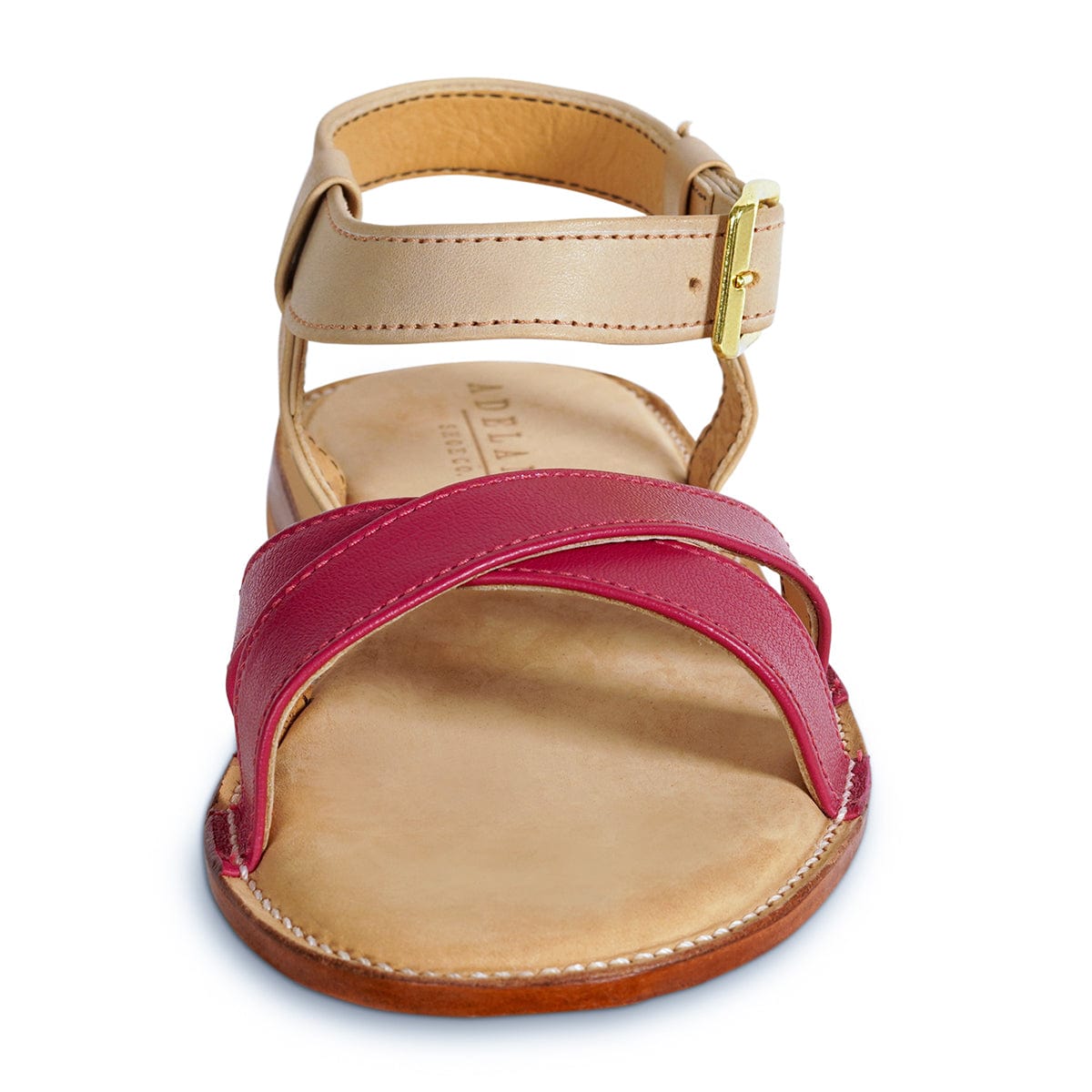 Women's handcrafted leather sandal with burgundy crisscross straps, tan adjustable ankle strap, cushioned footbed, and gold buckle detail