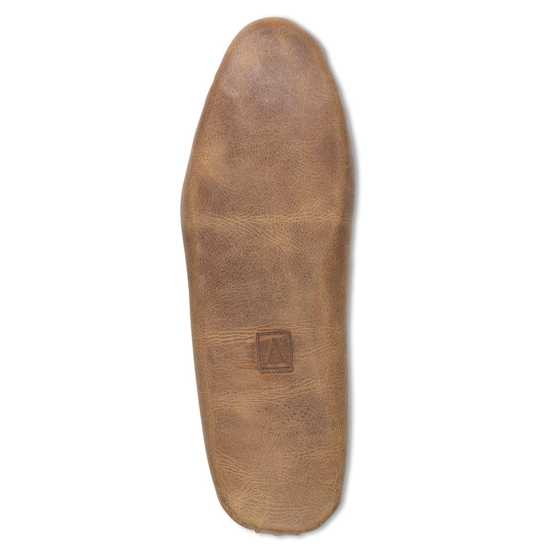 Men's wide tan leather moccasin, shown with the sole turned up, available to order in size 4.5