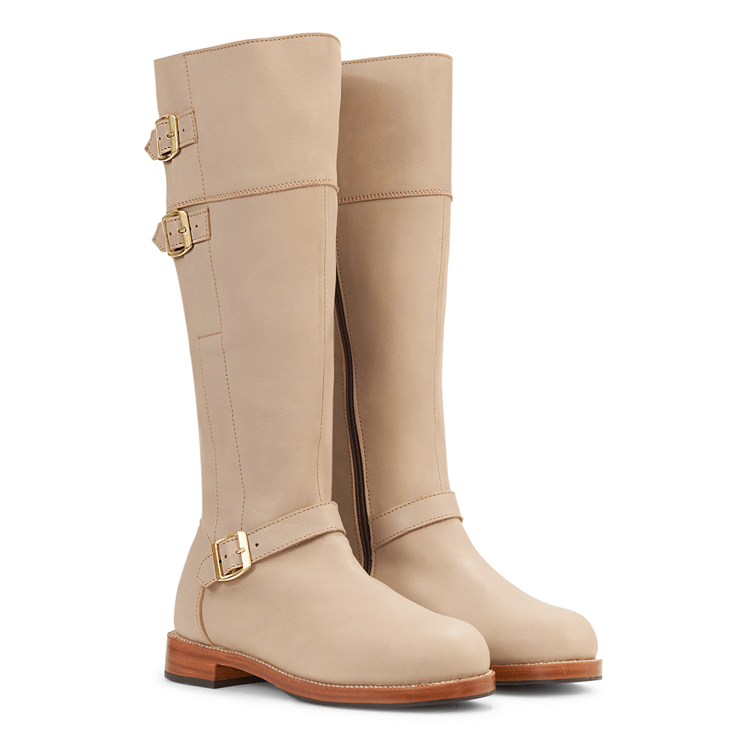 Beige women's knee high riding boots with brass buckles and wraparound leather detailing made to order in wide calf widths
