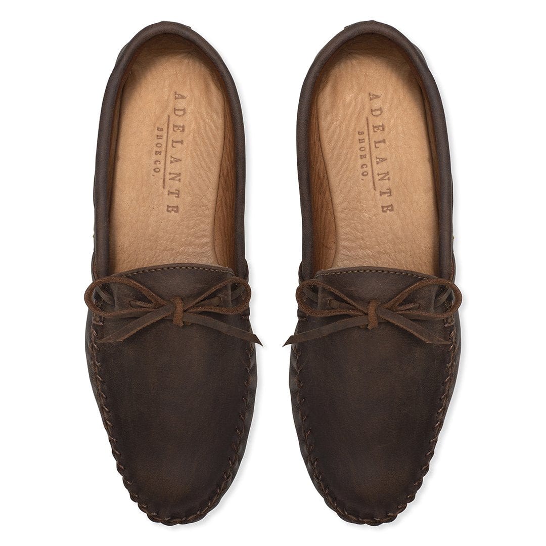 Women's brown leather moccasins with hand-stitched edges and tie laces viewed from above