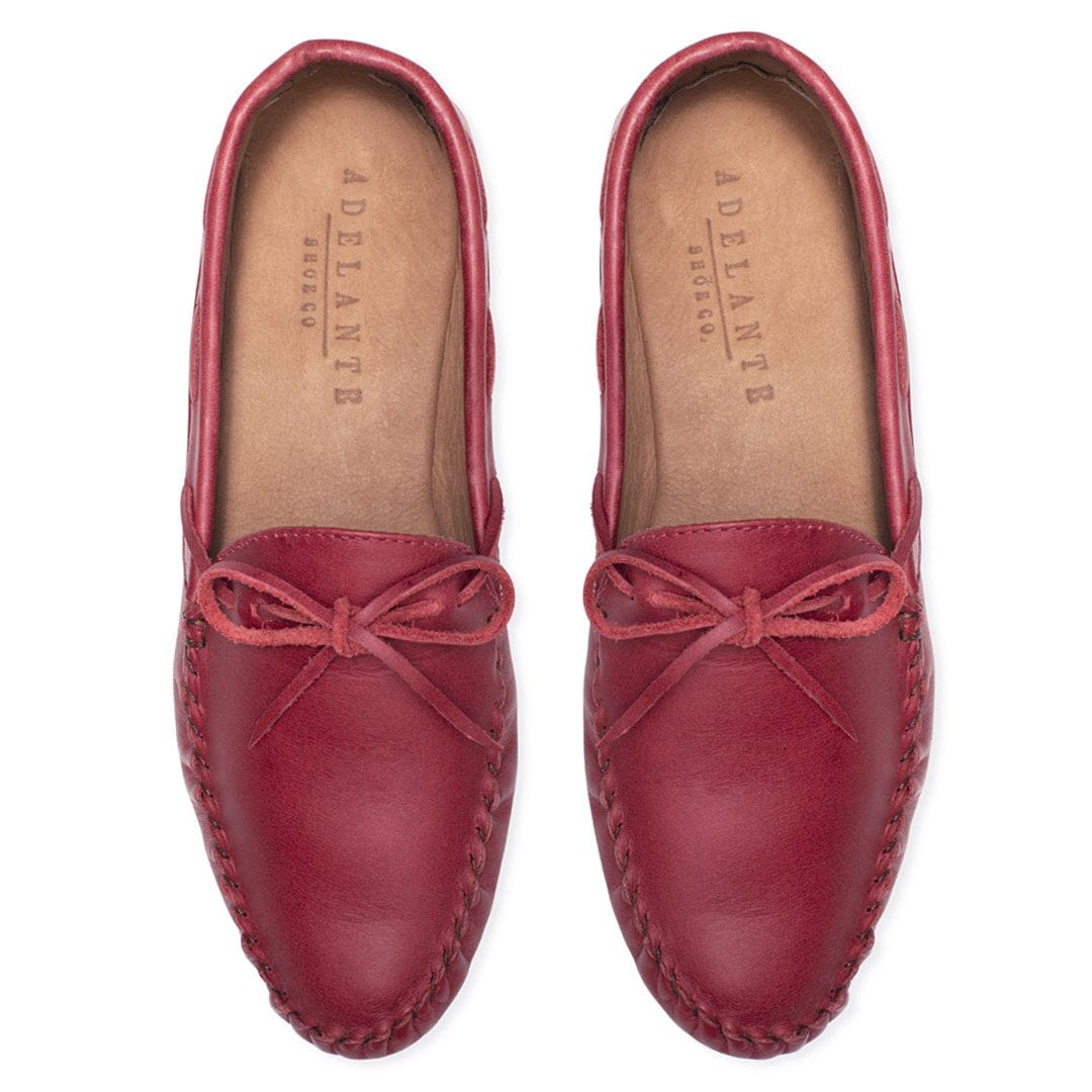 Burgundy leather moccasins with bow ties and hand stitched detailing, handcrafted by Adelante artisans