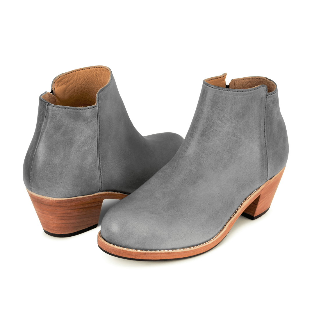 Gray leather women's ankle booties with tapered wood heels, shown as a pair and available in narrow to extra wide widths