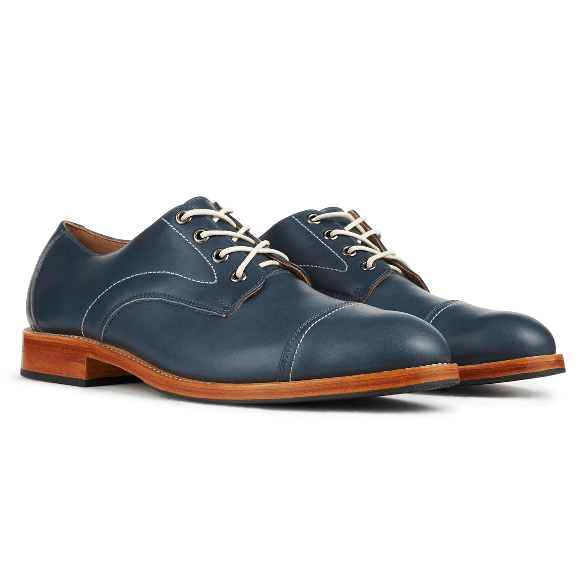 Pair of men's 3E-wide blue leather cap-toe derbies, shown from the front at an angle, made by hand in Guatemala – The Marco