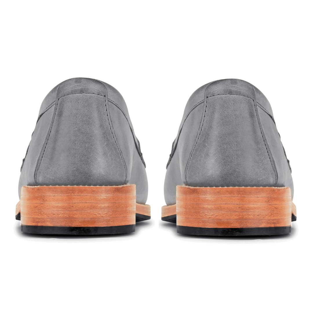 Women's gray leather loafers viewed from behind with stacked wood heels