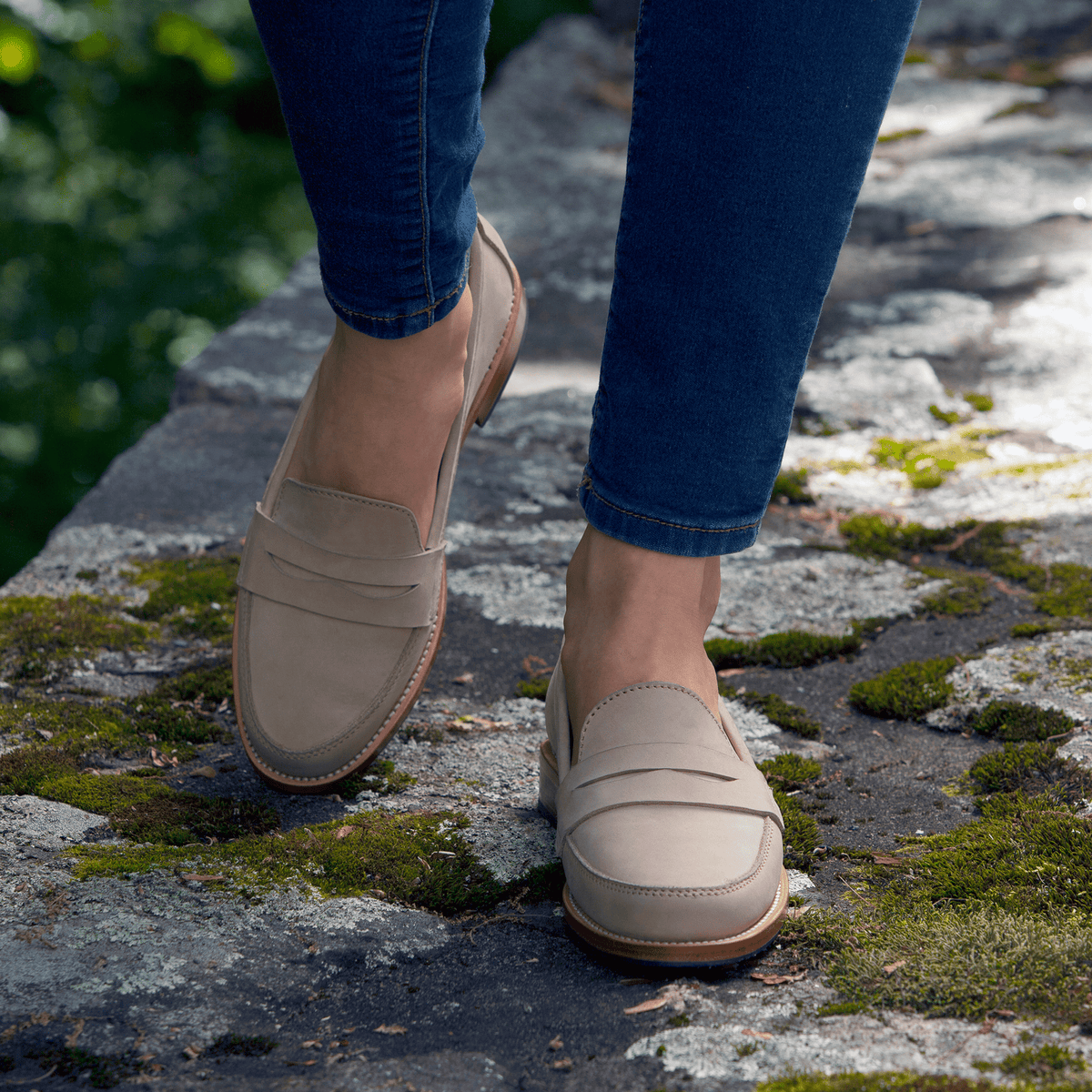 Adelante womens taupe leather penny loafers styled with jeans outdoors, available in sizes 4 to 8.5 and narrow to extra wide widths