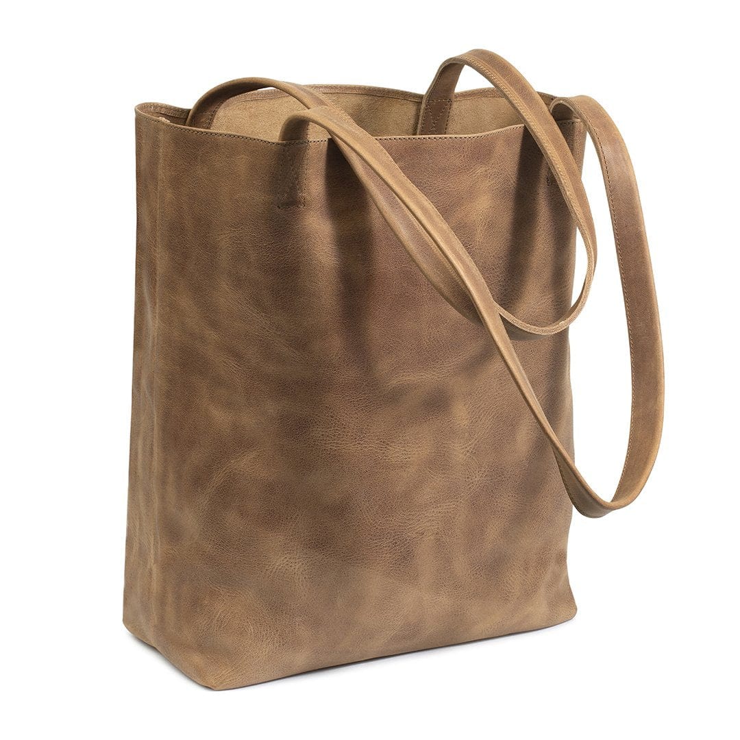 Tan leather tote bag, shown at an angle, stitched by hand in Guatemala