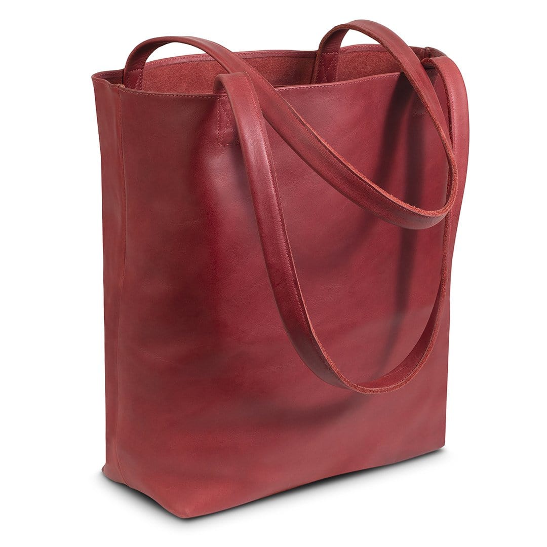Red leather tote bag, shown at an angle, stitched by hand in Guatemala